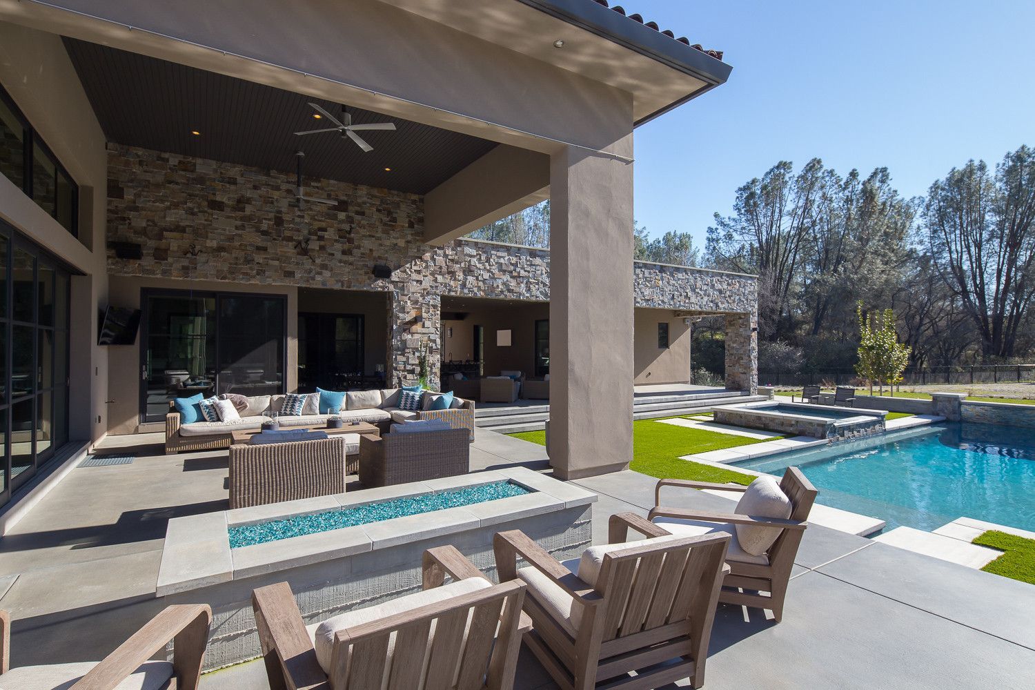 There is a large swimming pool in the backyard of a house.