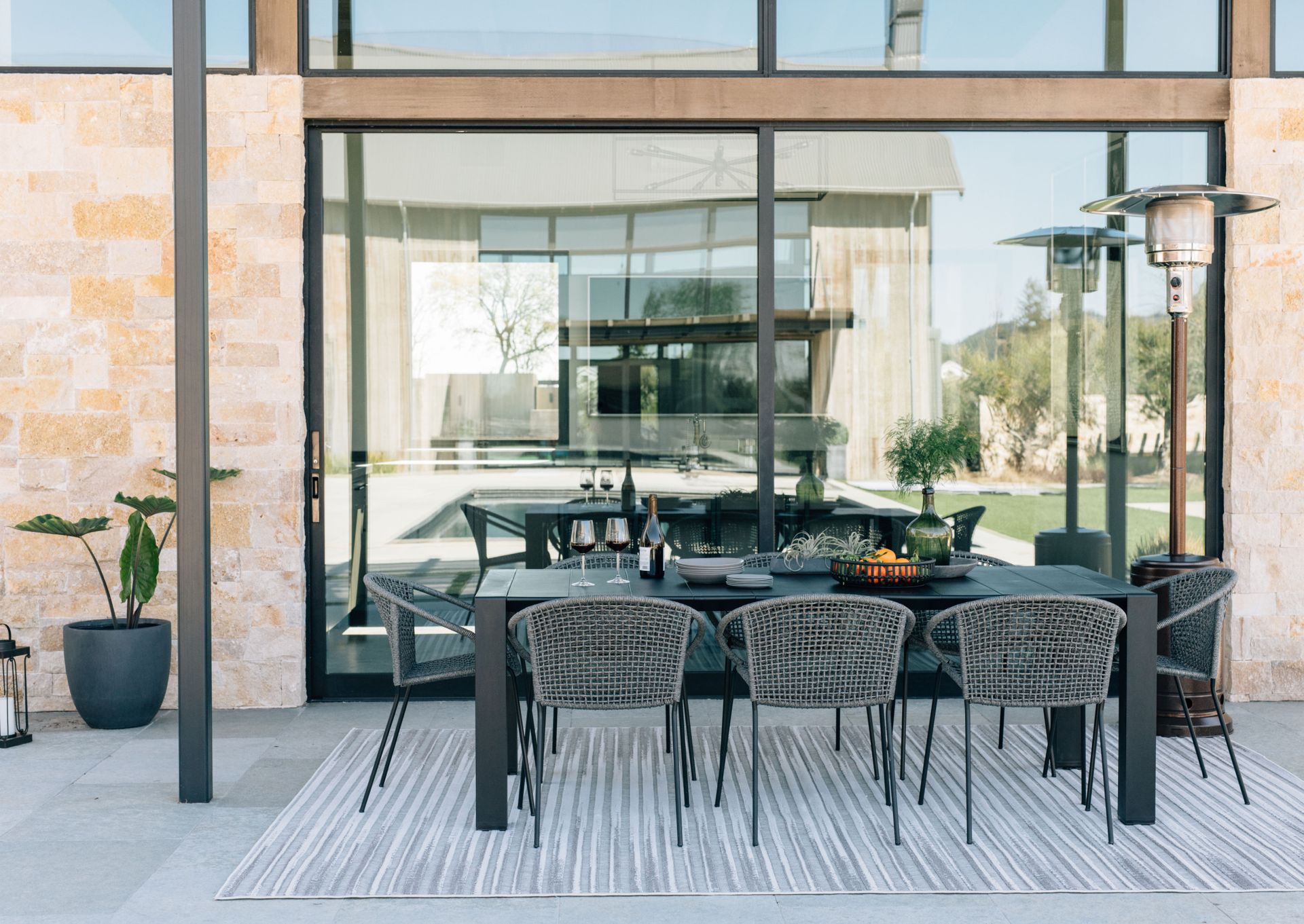 A patio with a table and chairs in front of a building.