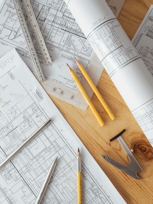 architecture maps, tools, and pencils on a wooden table