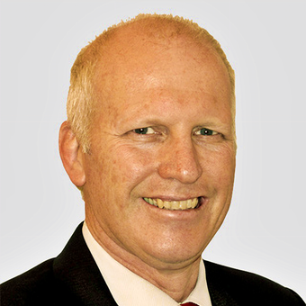 A man in a suit and tie smiles for the camera