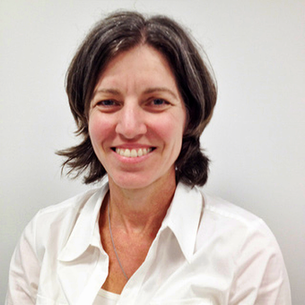 A woman in a white shirt smiles for the camera