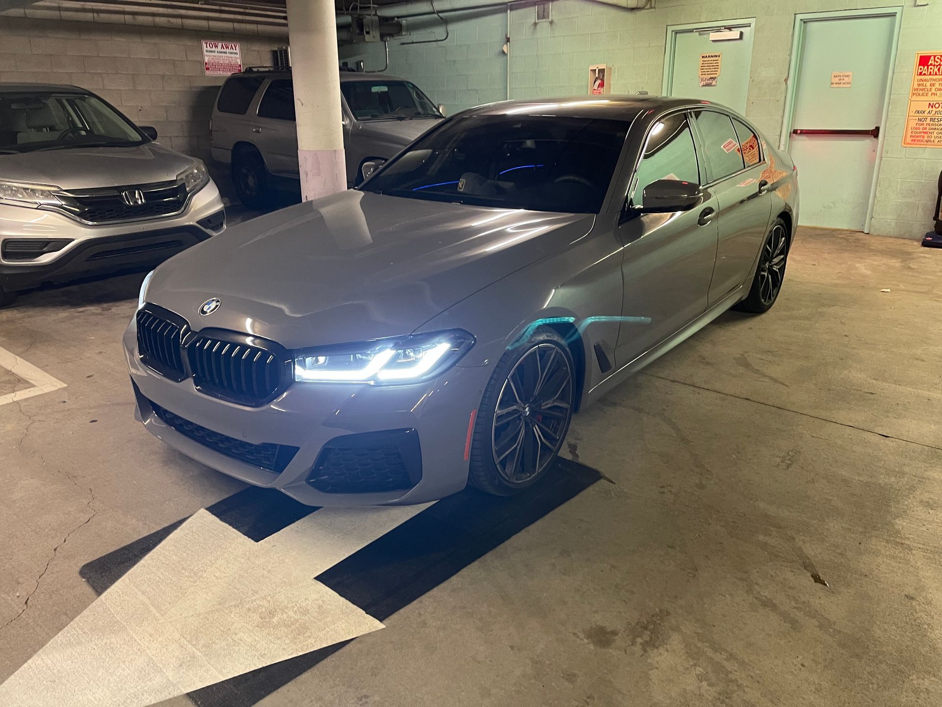 A bmw 5 series is parked in a parking garage.