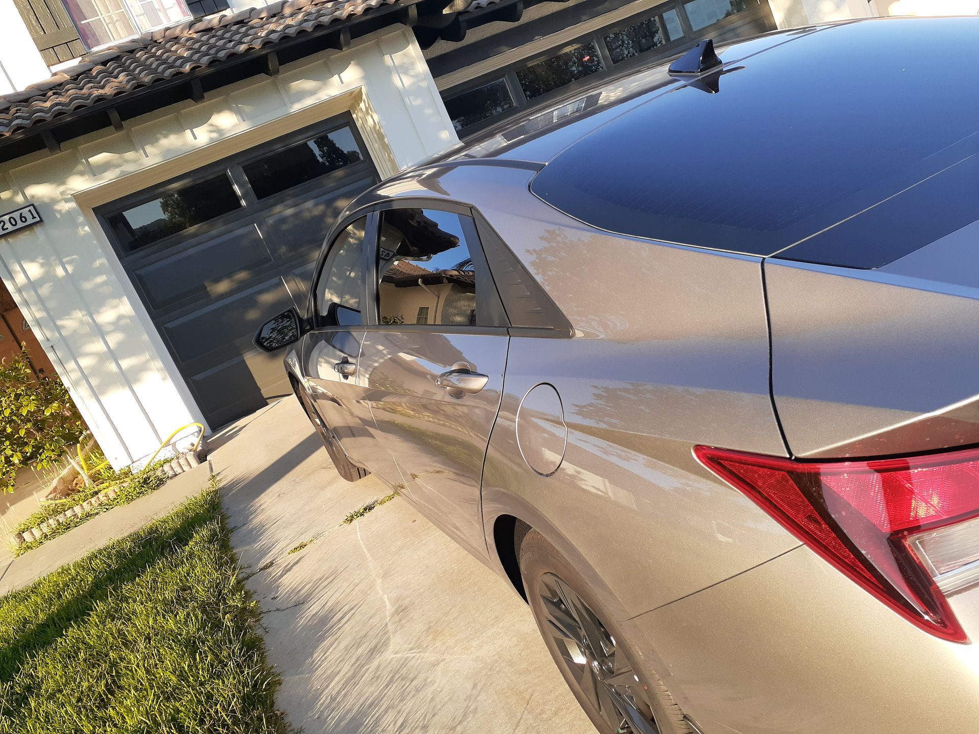 A silver car is parked in front of a garage door