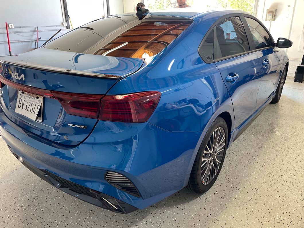 A blue car is parked in a garage.