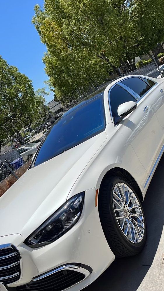 A white mercedes benz s class is parked on the side of the road.