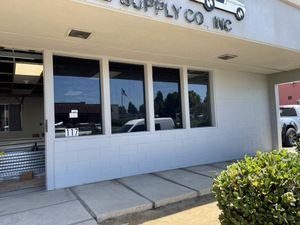 A white building with a sign that says supply co. inc