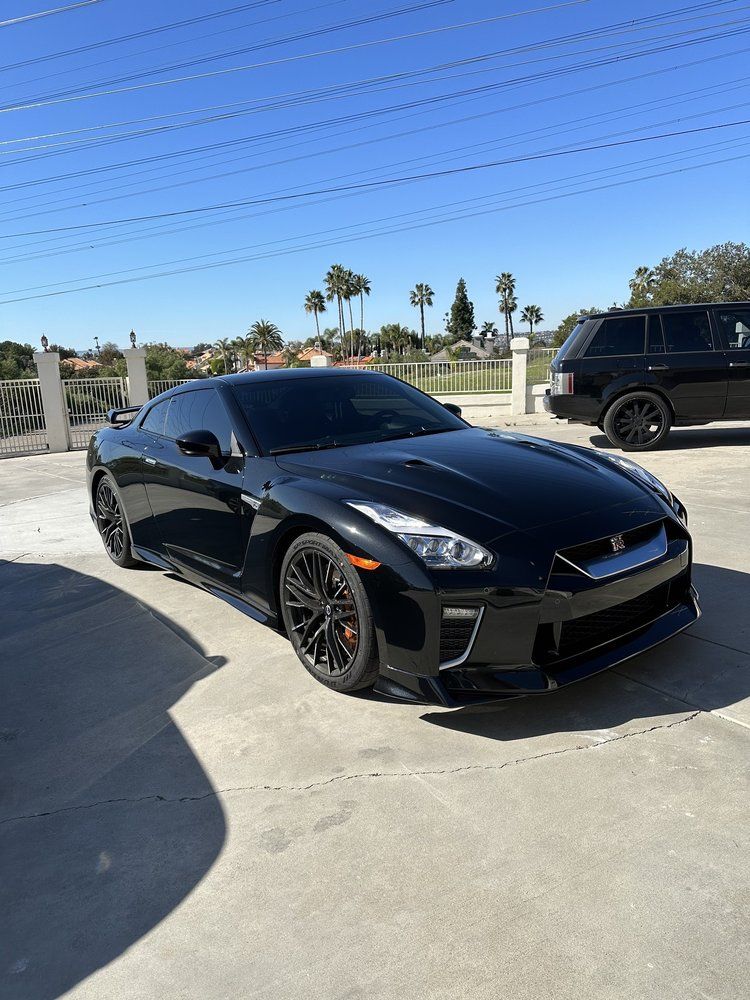A black sports car is parked in a parking lot next to a range rover.