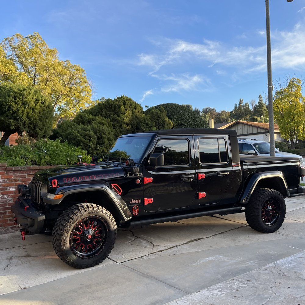 A black jeep is parked on the side of the road