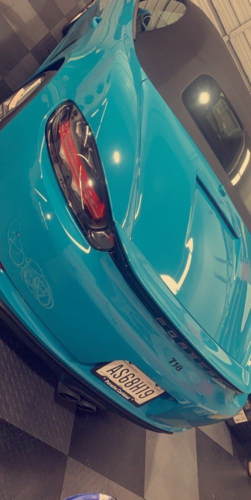 A blue sports car is parked in a garage.