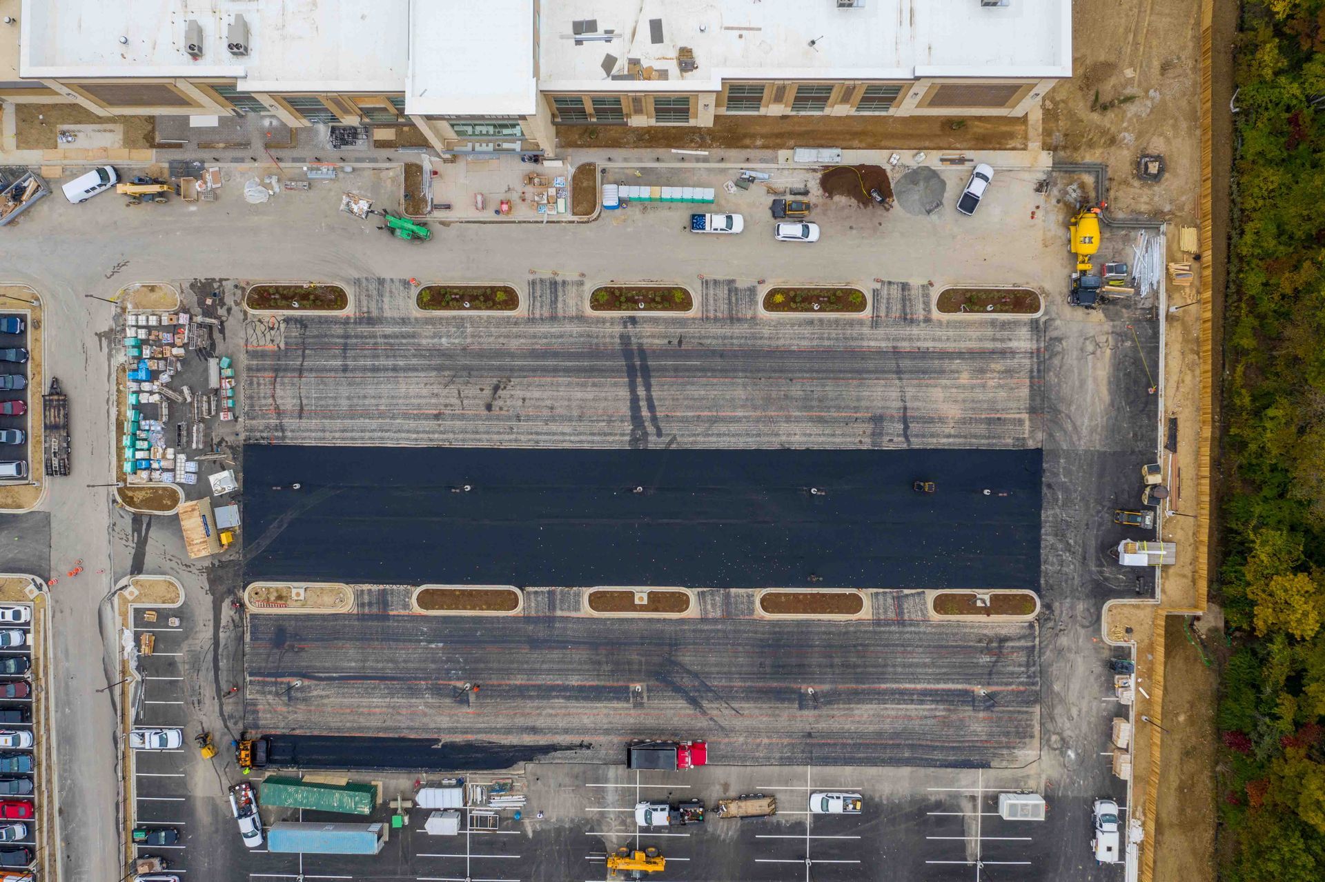 Aerial view of a parking lot with some asphalt laid down.