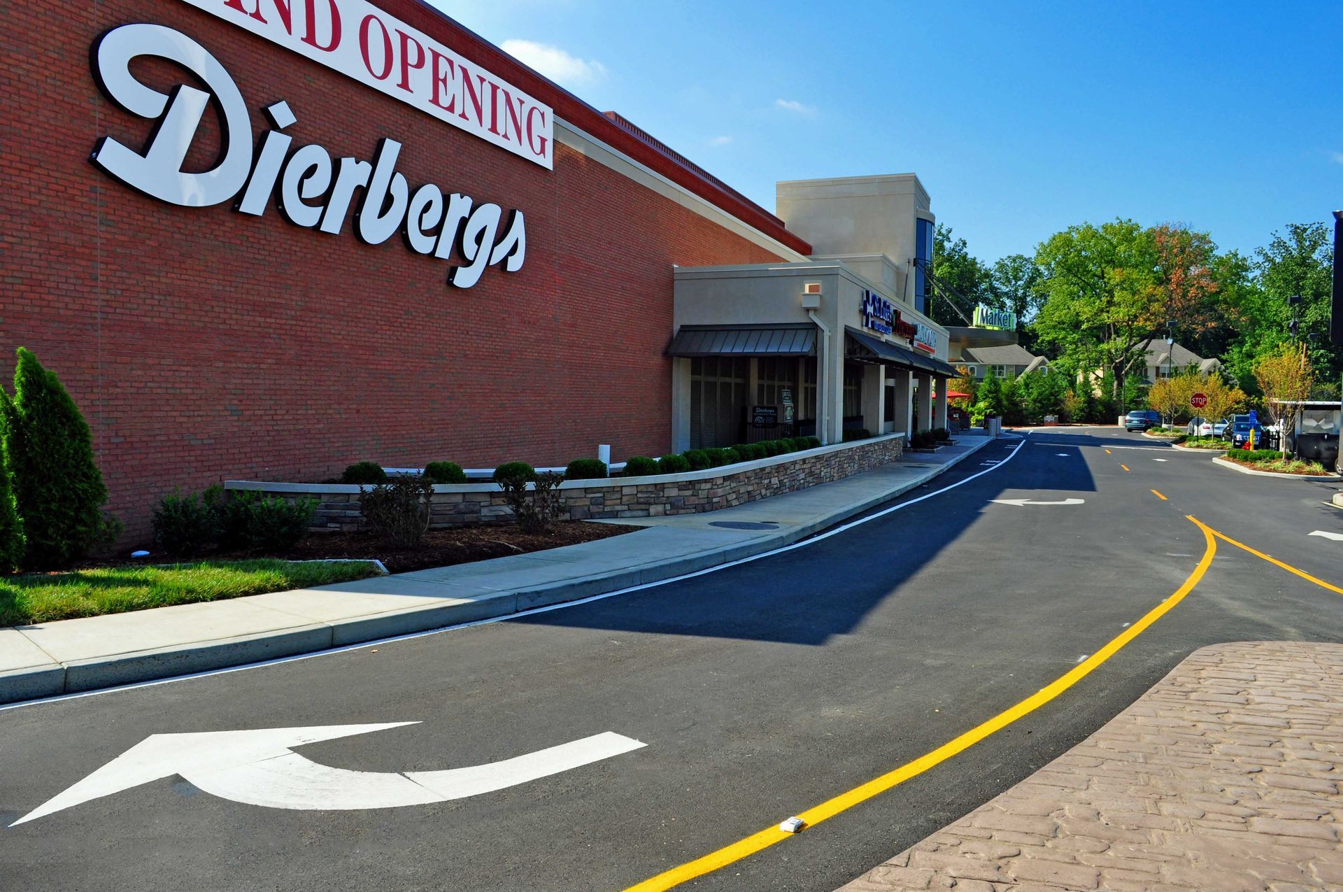 Dierbergs storefront with brick facade, drive-up lane, and parking lot on a sunny day