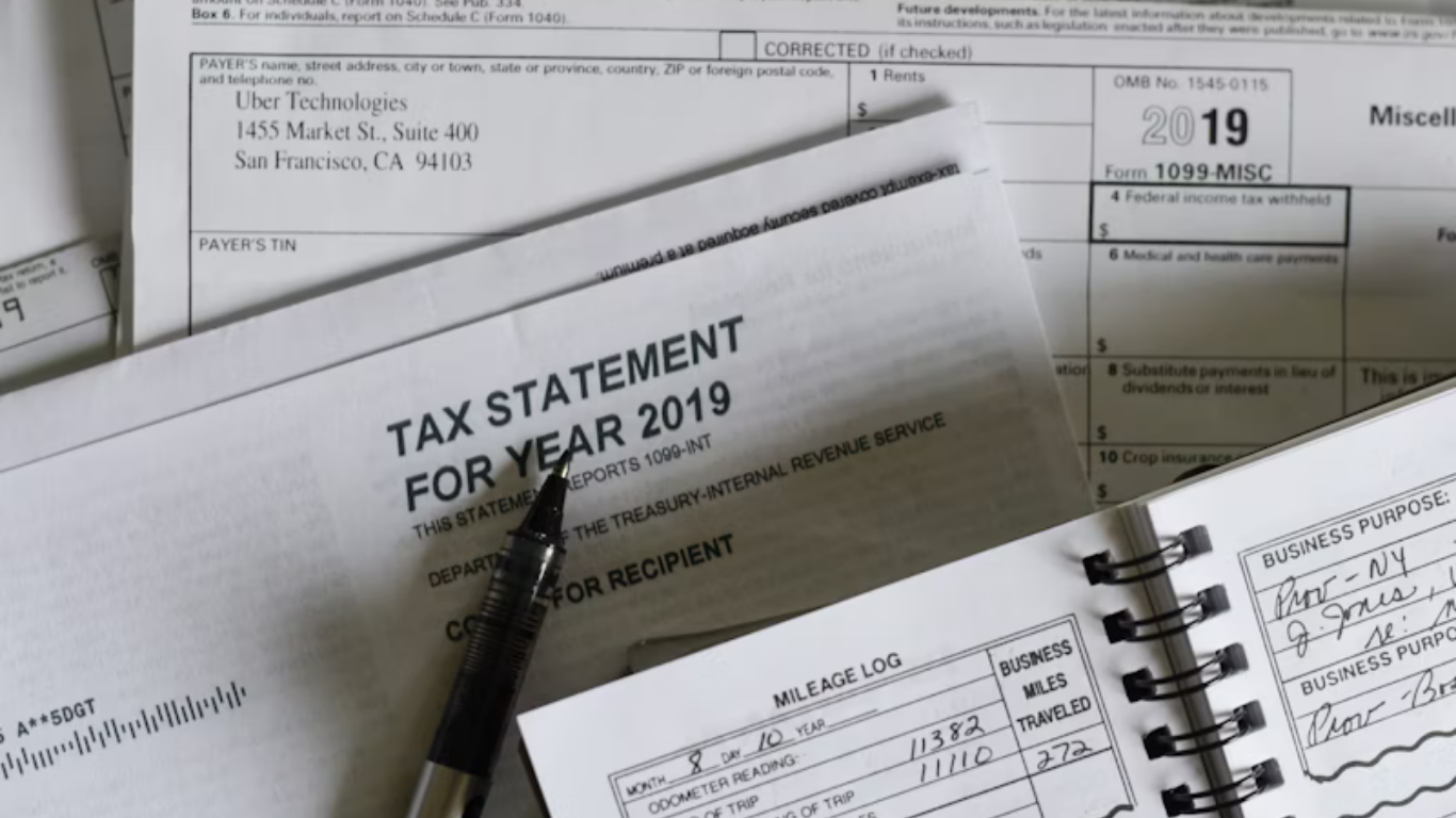 Tax forms, pen, and notebook on a desk; paperwork for 2019 taxes.