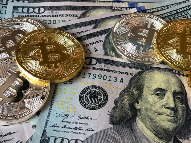 Bitcoin coins on US $100 bills.