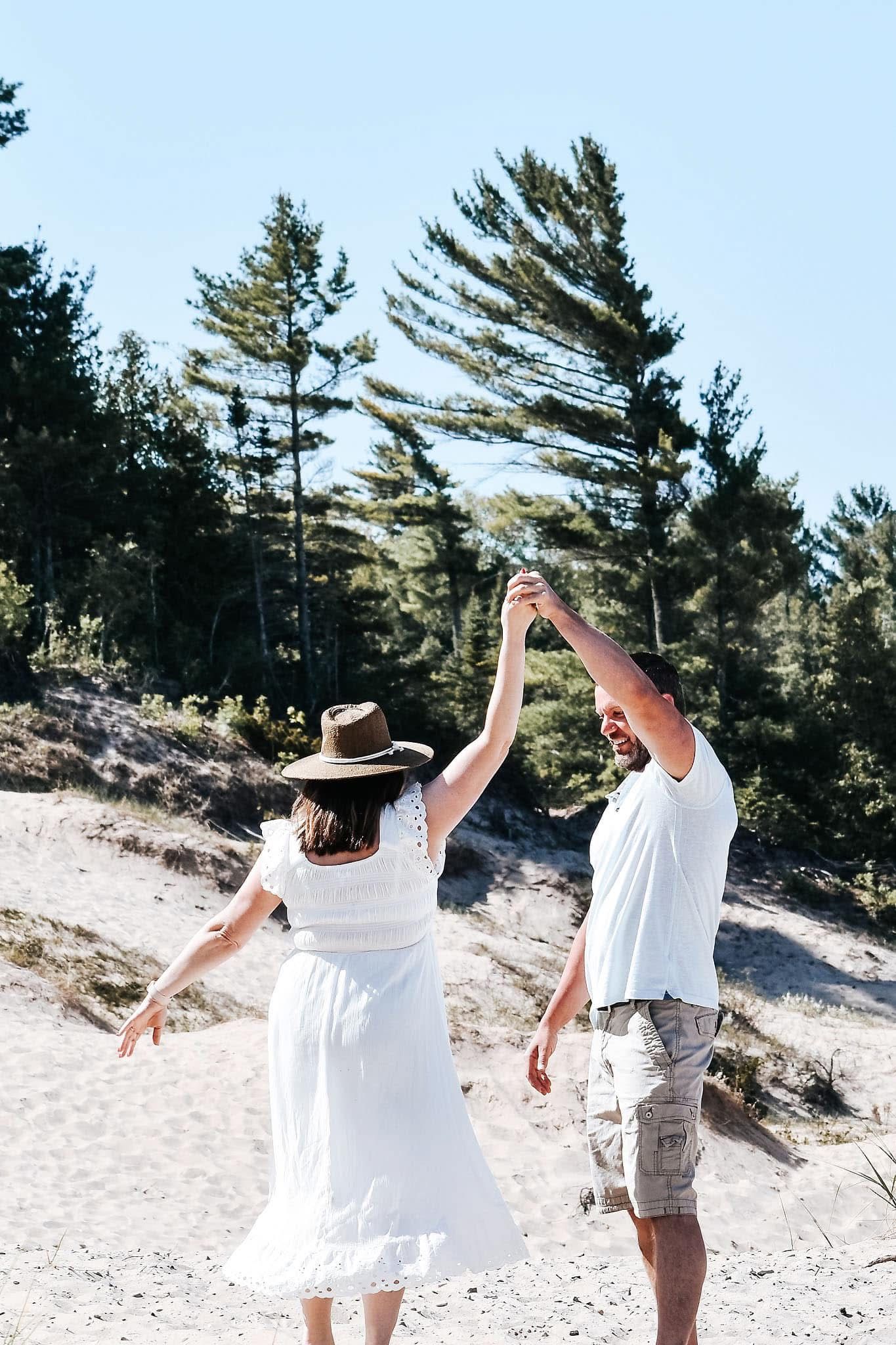 A man and a woman are dancing on the beach.
