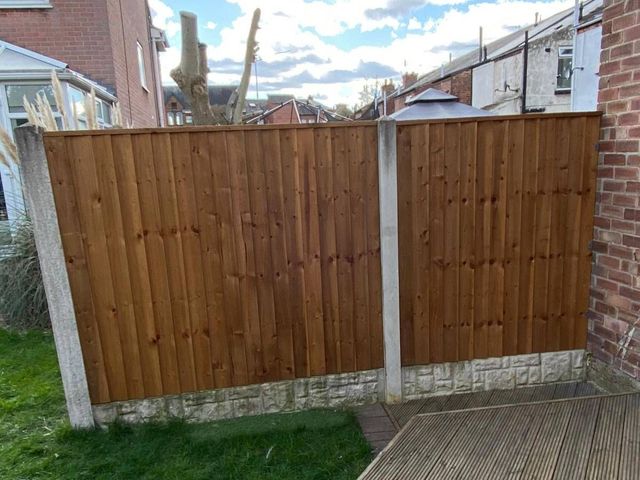 New closeboard fence panels on concrete posts with rock-faced gravel boards beside decking in Newark
