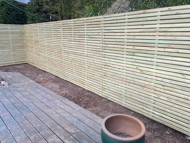 A completed run of horizontal slatted privacy screening along the edge of a Keyworth garden