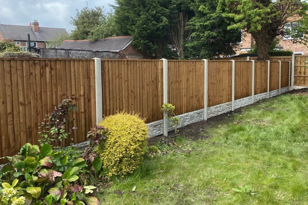 A completed run of closeboard fence panels on concrete posts with rock-faced gravel boards in a Carlton garden