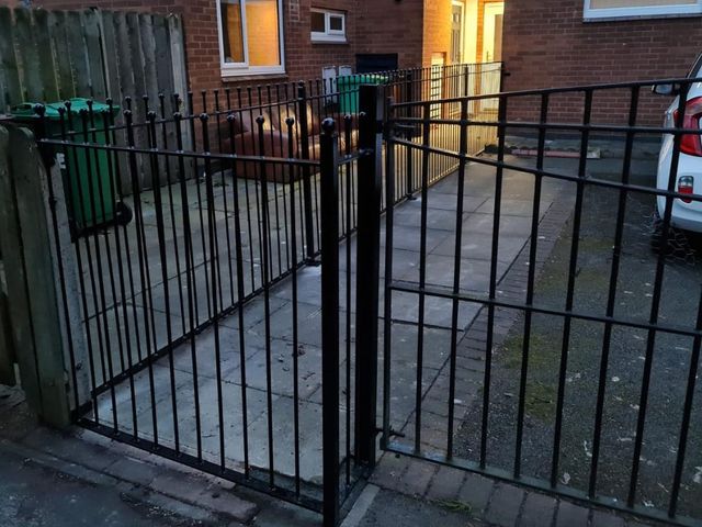 Matching metal gate attached to installed ball top railings