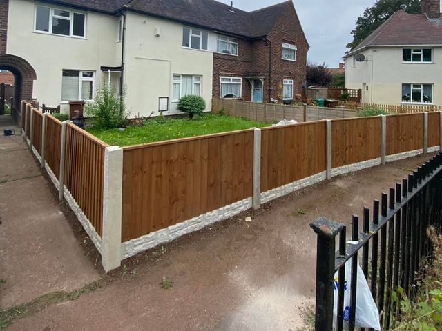 A timber front garden fence on concrete posts with rock-faced gravel boards outside semi-detached houses in Gamston