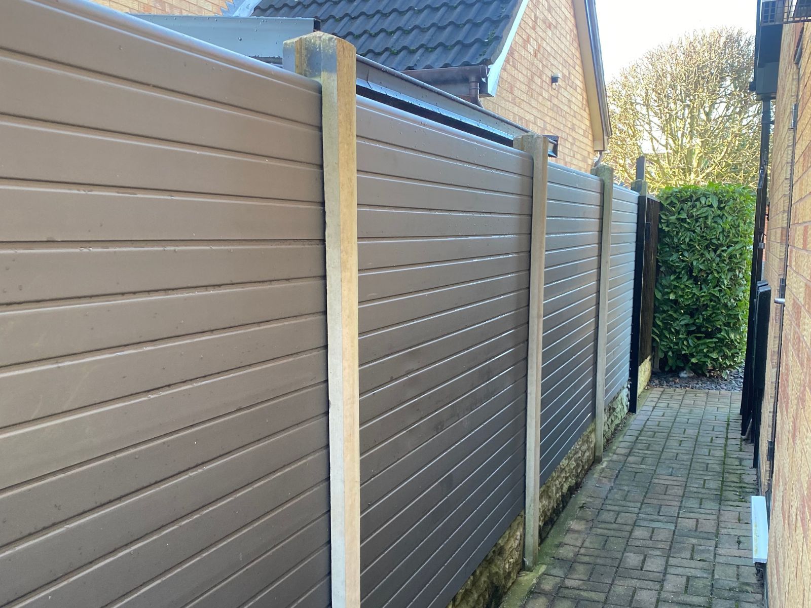 Grey composite fencing installed by Nottingham Fencing between existing concrete posts