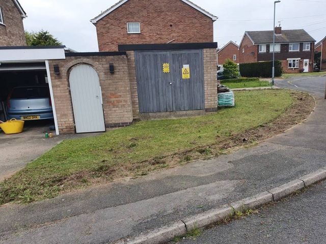 The same Selston frontage with the hedge removed, showing the cleared bank and the garage