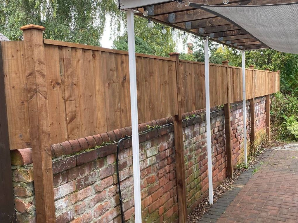 Closeboard timber fence panels on timber posts fitted above an existing red brick garden wall in Beeston