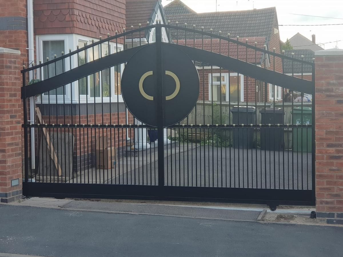 Nottingham Fencing Single sliding arched metal driveway gate with embossing and gold ball bar tops