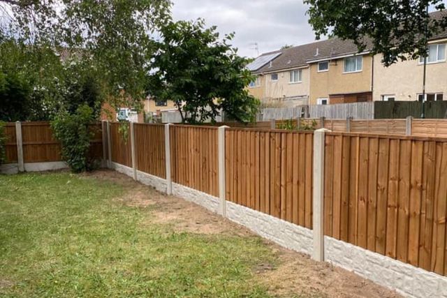 A completed closeboard fence on concrete posts with rock-faced gravel boards along a Top Valley garden boundary