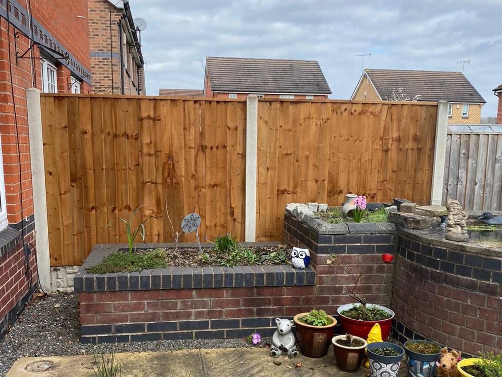 New featheredge closeboard fence panels fitted into existing concrete posts in a Basford garden