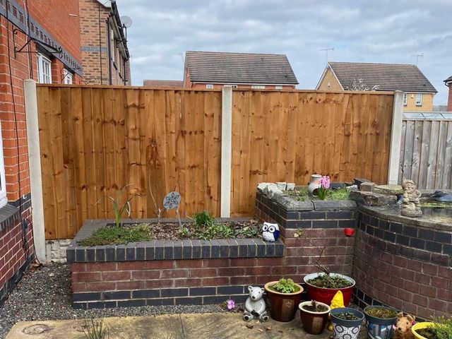 New featheredge closeboard fence panels fitted into the existing concrete posts in a Basford garden