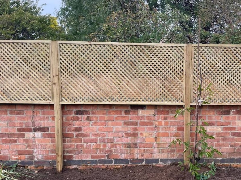 Diamond trellis panels fitted on timber posts above an old red brick garden wall in Clifton