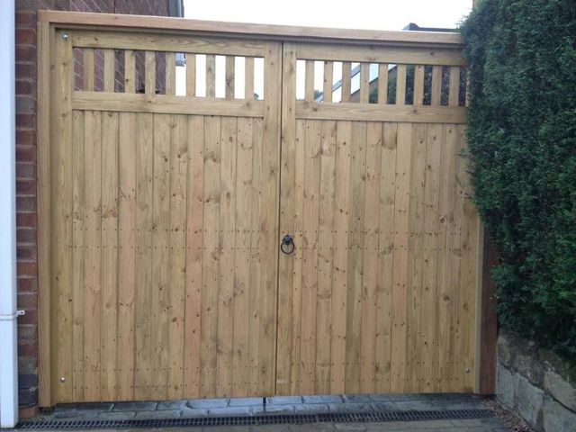 Wooden double driveway gates with a slatted top section fitted across a drive in Calverton