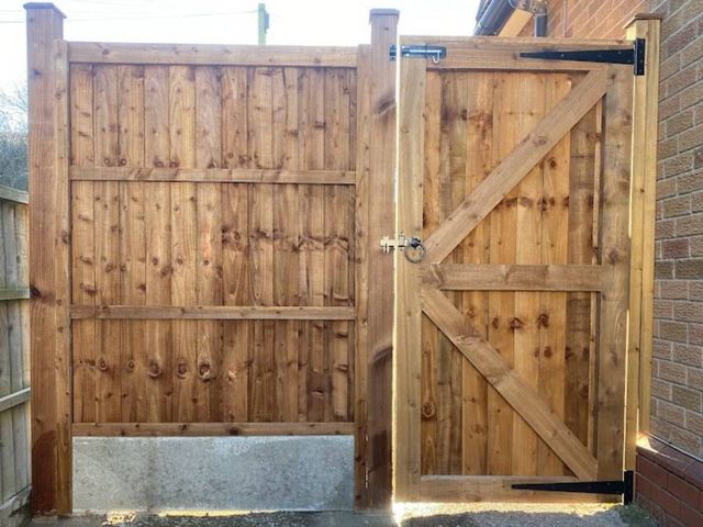 Braced and ledged timber side gate with a ring latch, hung beside new closeboard fence panels in Calverton