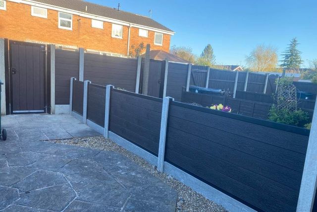 Anthracite grey composite fencing on concrete posts beside a paved patio in Arnold