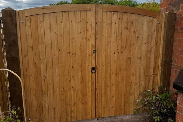 Arched top timber double gates with a smooth outer face in West Bridgford