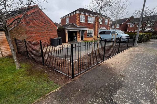Black ball-top metal railings enclosing a front garden and driveway in Long Eaton