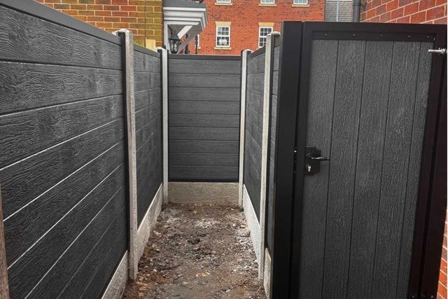 Black composite fencing and gate lining a narrow side passage in West Bridgford