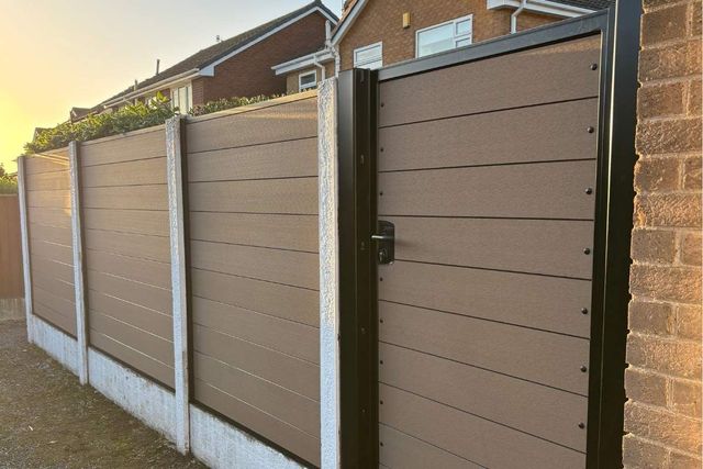 Brown composite fencing and a matching composite gate in a black metal frame in Arnold