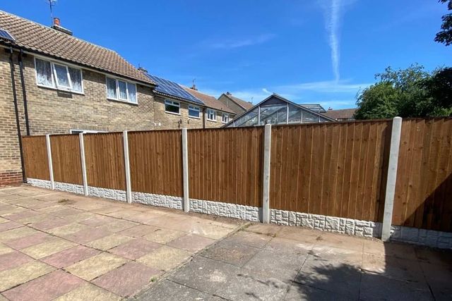 A long run of closeboard fencing on concrete posts with rock-faced gravel boards in Hucknall