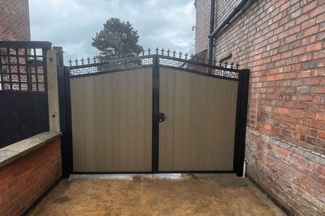 Natural oak coloured composite driveway gates with fleur-de-lis finials in Long Eaton