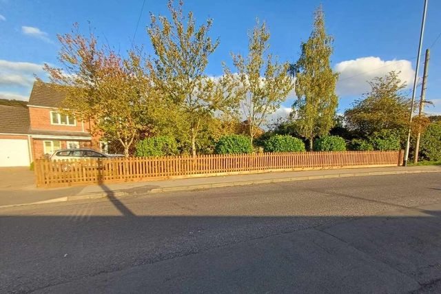 Timber picket fencing along a front garden boundary in Forest Town seen from across the road