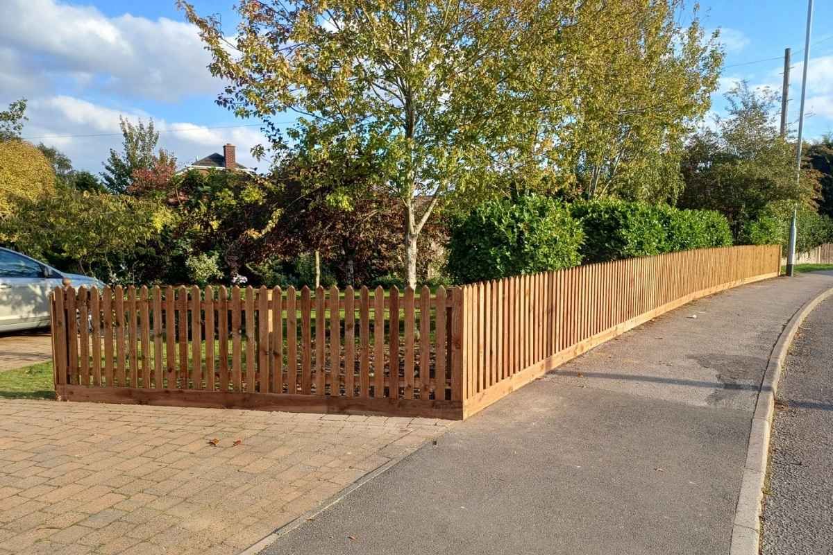 New timber picket fencing running along a front garden boundary beside the pavement in Forest Town, Mansfield