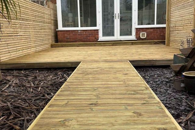 Garden decking with a walkway and slatted timber screening in West Bridgford
