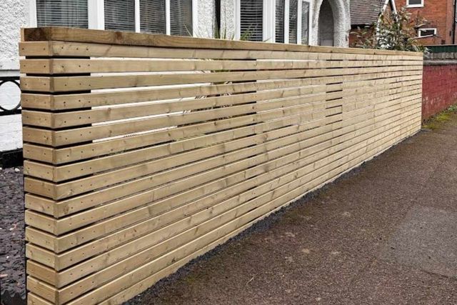 Horizontal slatted timber fencing beside a slate chipping border in West Bridgford