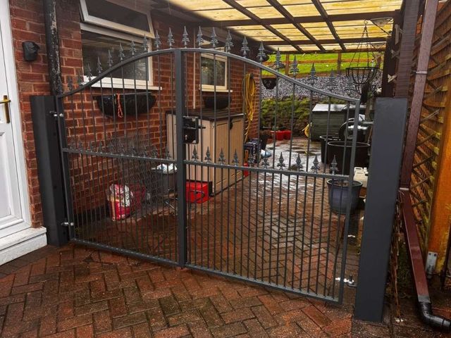Anthracite metal driveway gates with spear finials fitted across a passage in Arnold, Nottingham