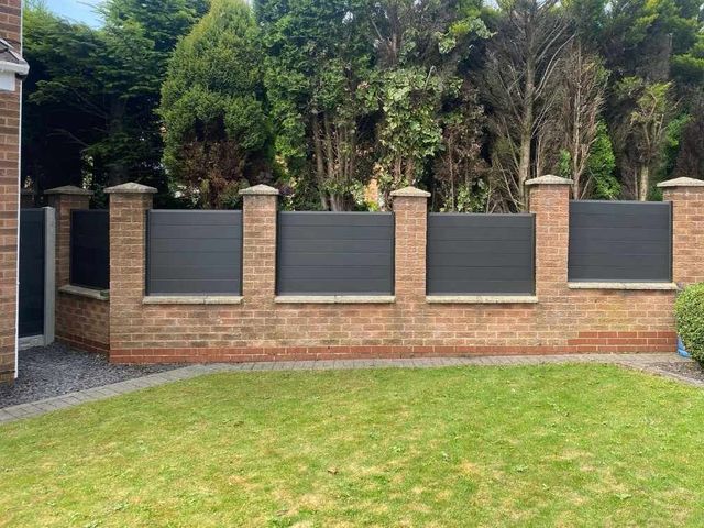 Anthracite grey composite panels fitted between brick pillars along a rear garden boundary