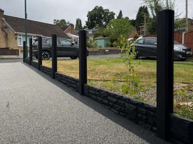 Black painted concrete posts and rock-faced gravel boards installed ready for composite fence panels in Bulwell