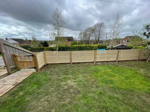 New slatted fencing and a timber garden gate running alongside an older weathered lap fence panel