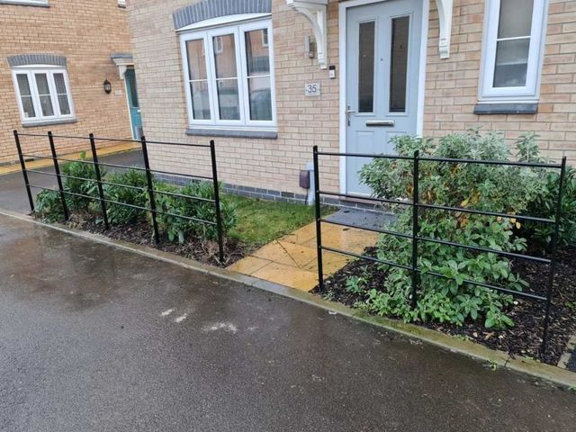 Estate style metal railings forming a front boundary outside a row of townhouses