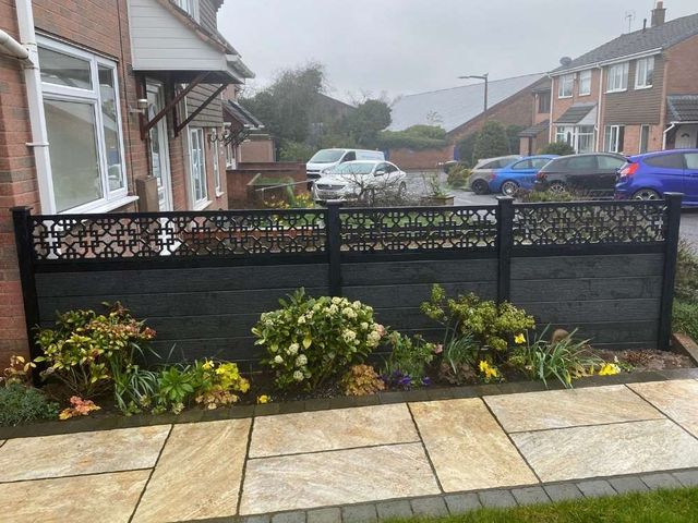 Black composite fencing with cathedral design toppers behind a planted front border
